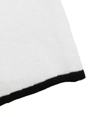 Close up of white knit fabric with black ribbed trim along the hem.