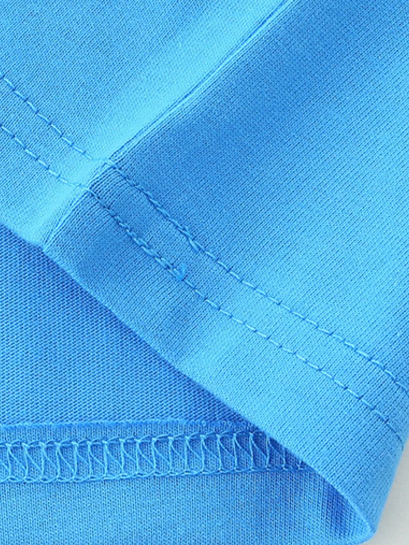 Close up of sky blue children's t-shirt seam stitching and smooth cotton fabric