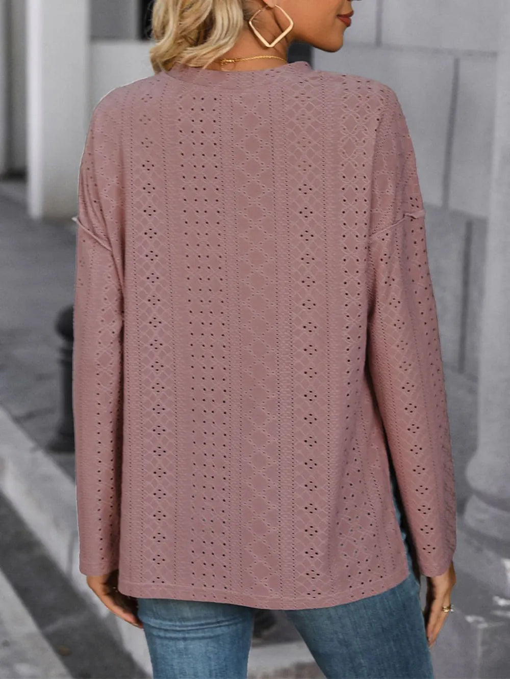 Back view of a mauve eyelet long-sleeve top with a round neckline and straight hem.