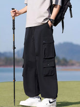 Men's black loose-fit multi-pocket cargo pants with a drawstring waist.