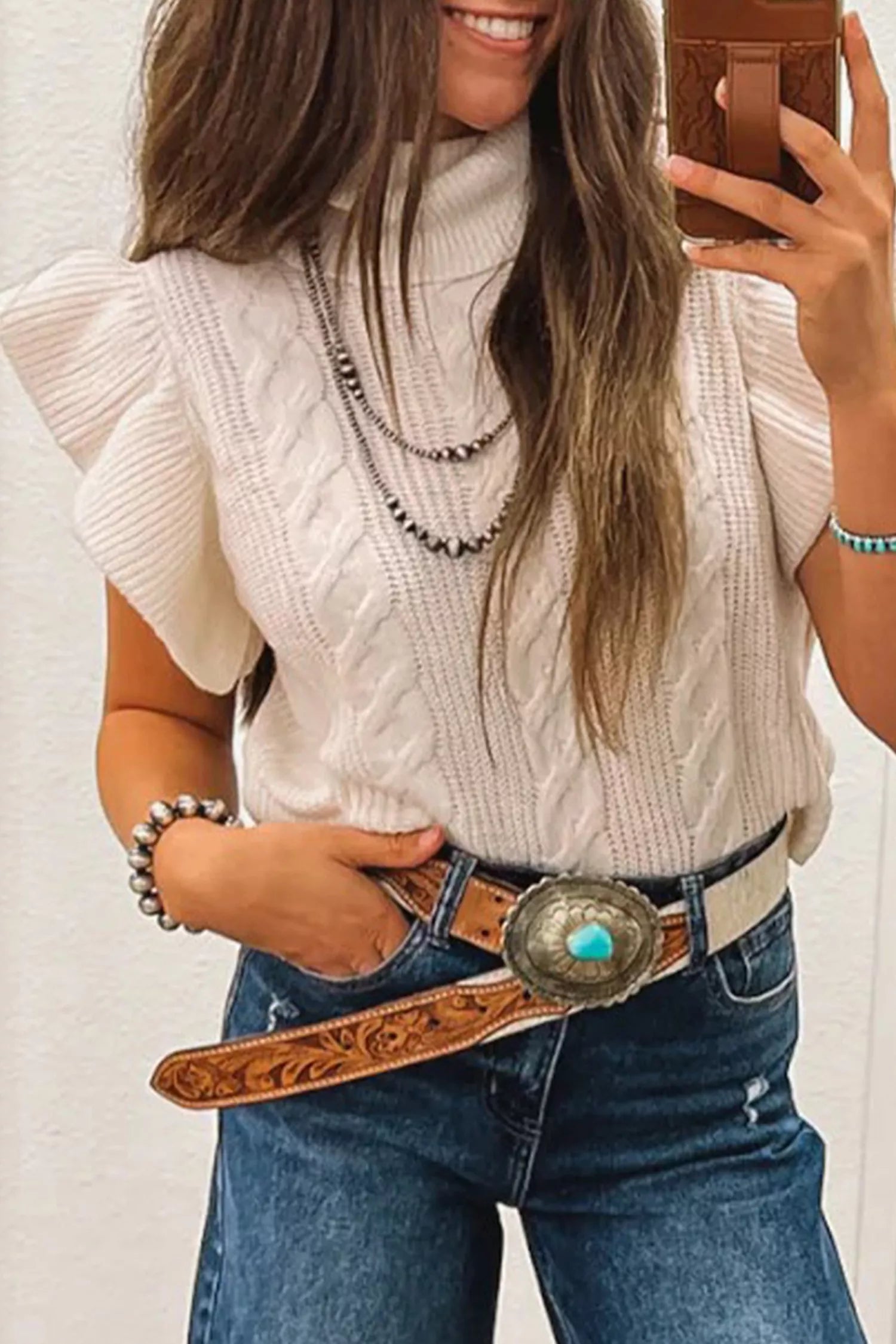 Mirror front view of an off-white cable knit turtleneck sweater with ruffled short sleeves