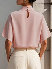 Back view of pink mock neck short-sleeve top with button closure and keyhole opening