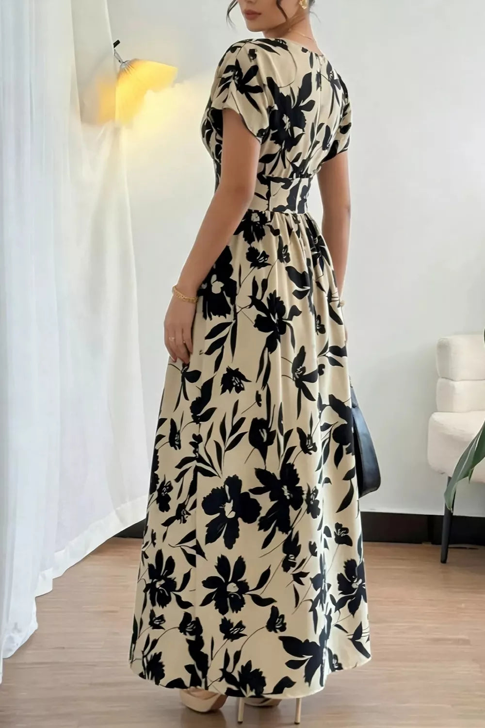 Back view of khaki floral short sleeve maxi dress with gathered waist and flared skirt