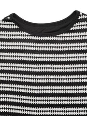 Close up flat detail of a black and white striped knit dress neckline
