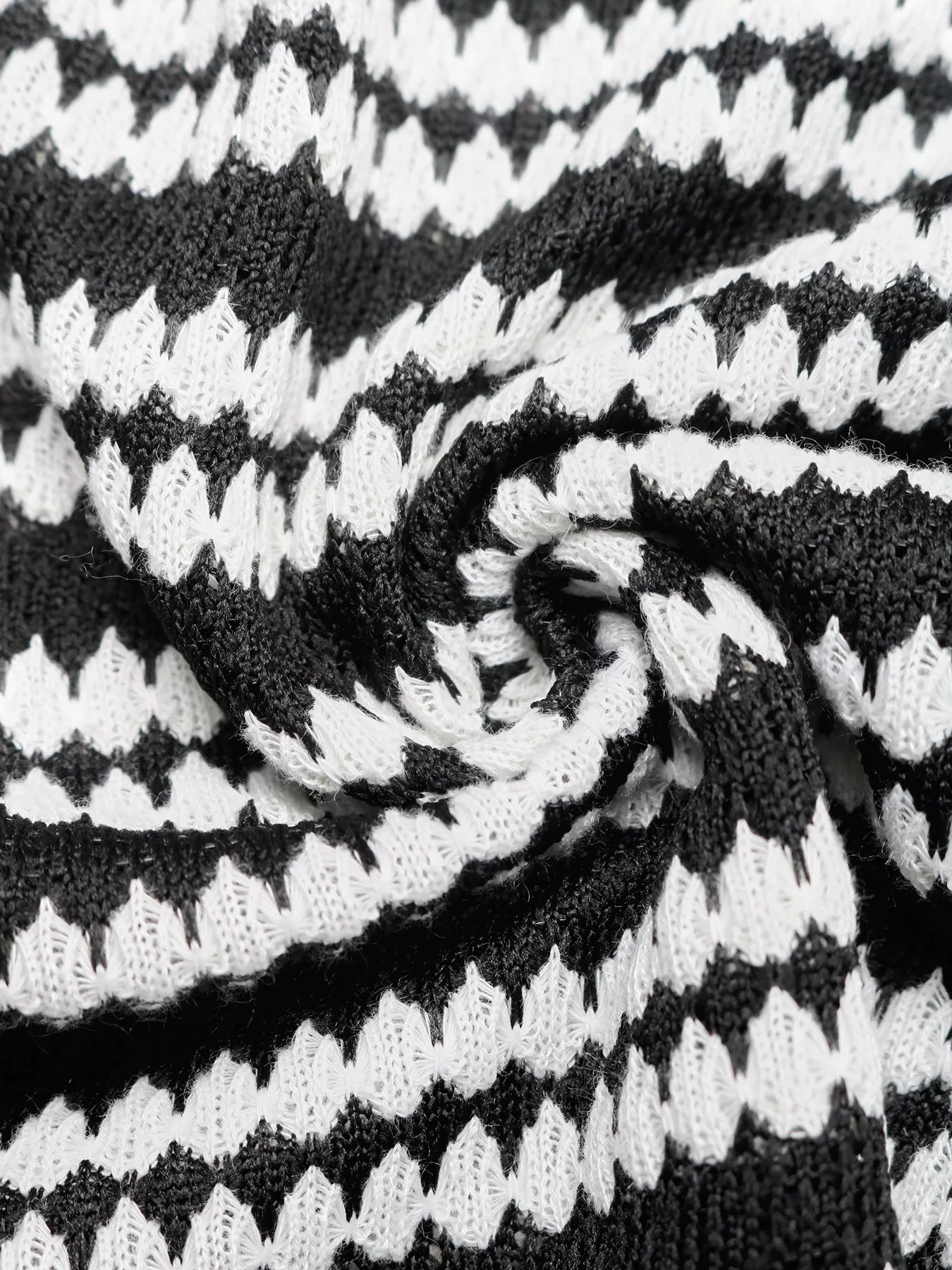 Close up fabric detail of a black and white striped knit dress showing the knit texture