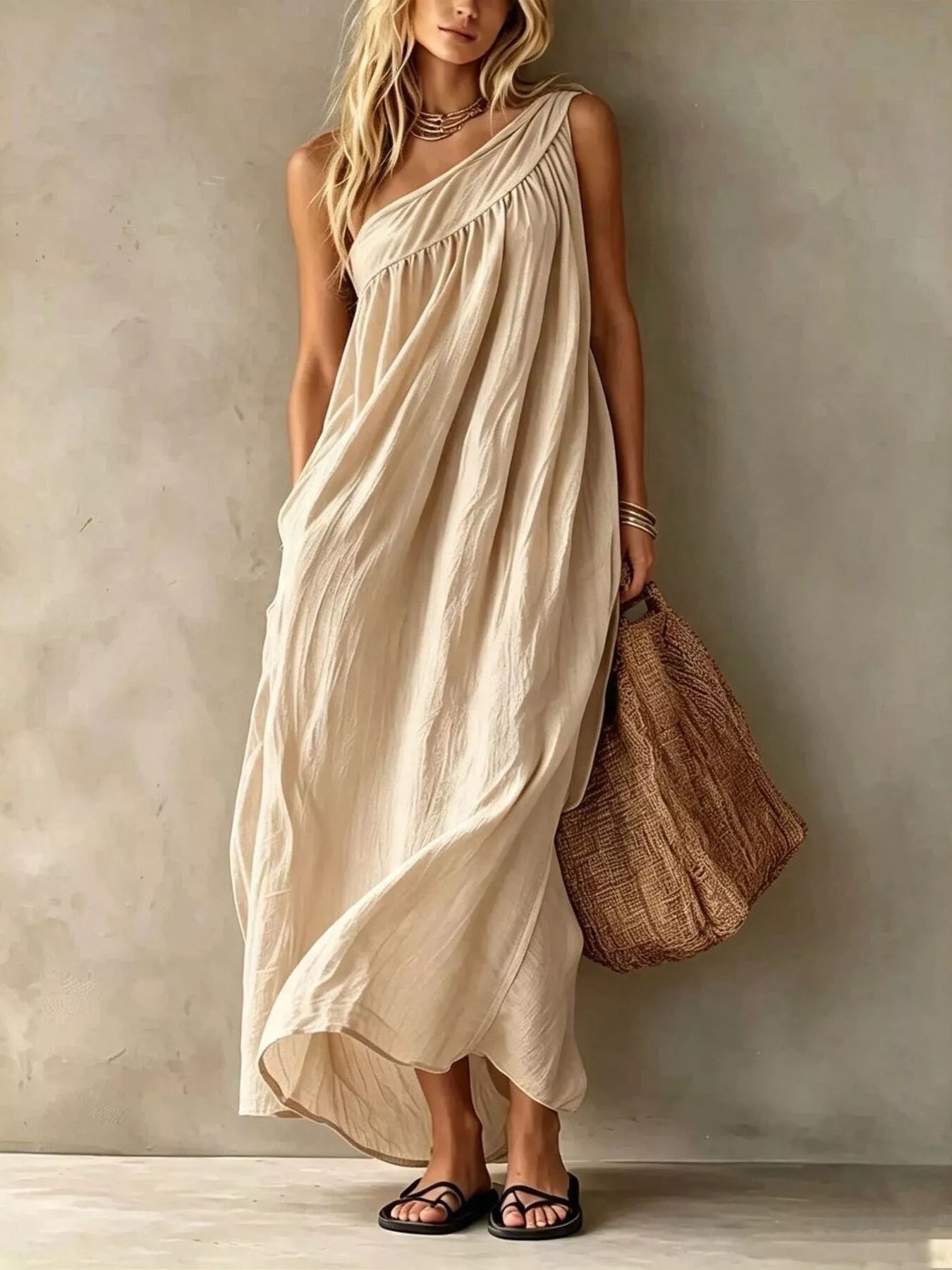 Full length front view of a beige one shoulder maxi dress with gathered bodice on a model
