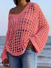 Front view of coral pink openwork crochet knit cover up worn off the shoulder at the beach.