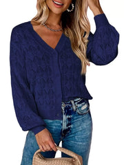 Front view of navy openwork leaf knit cardigan with V neck and button front.