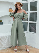 Women's sage jumpsuit with spaghetti straps and wide legs.