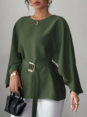 Army green round neck blouse front view holding black handbag with gold buckle belt