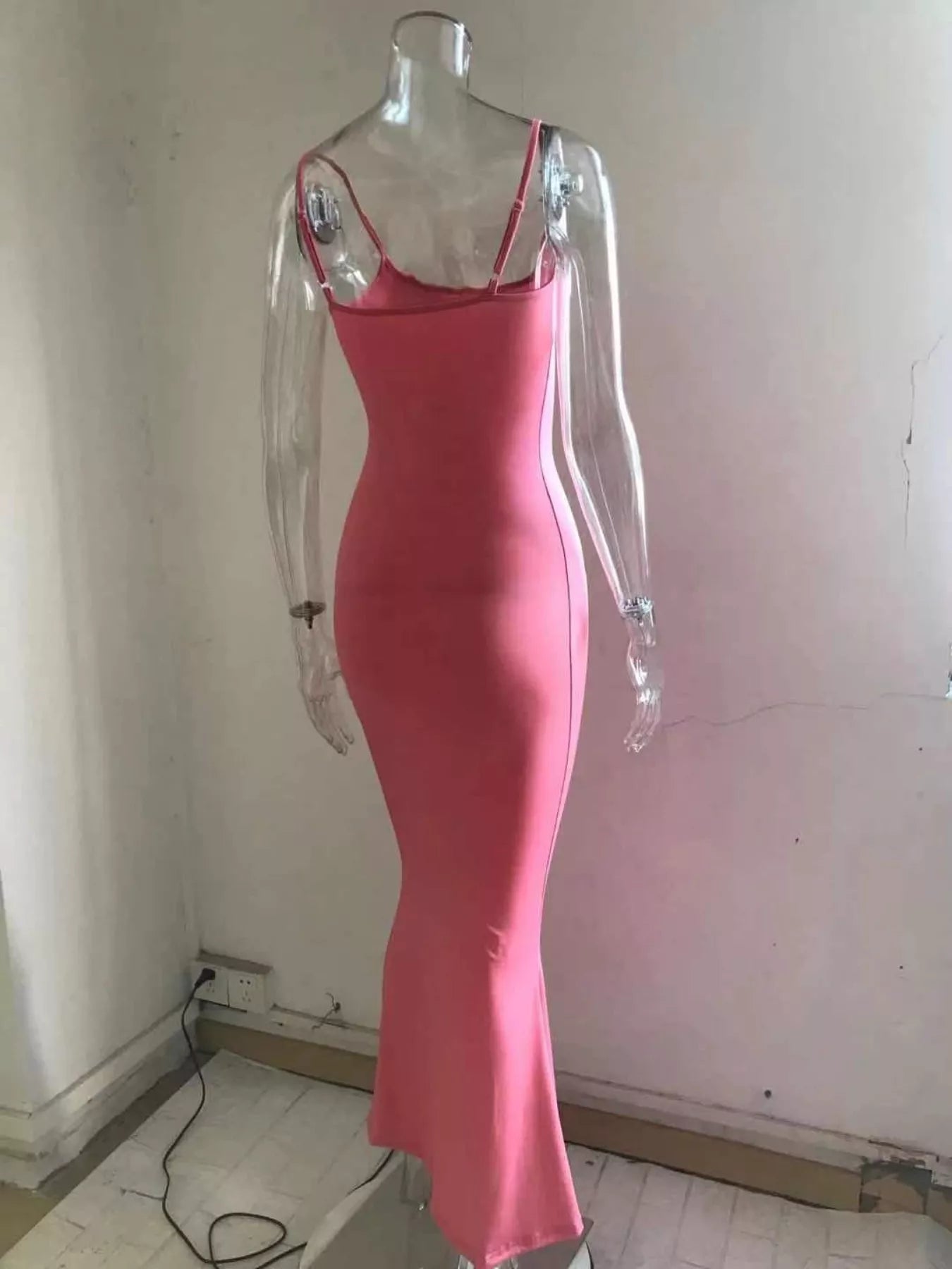 Back view of a burnt coral spaghetti strap bodycon maxi dress on a clear mannequin showing the straps