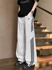 Men's light gray striped wide-leg pants with a drawstring waist and pockets.