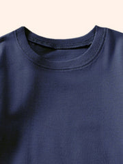 Close-up of the ribbed round neckline on a plain dark navy children's T-shirt
