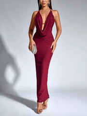 Dark red glitter halter neck bodycon maxi dress worn full length standing straight holding a clutch