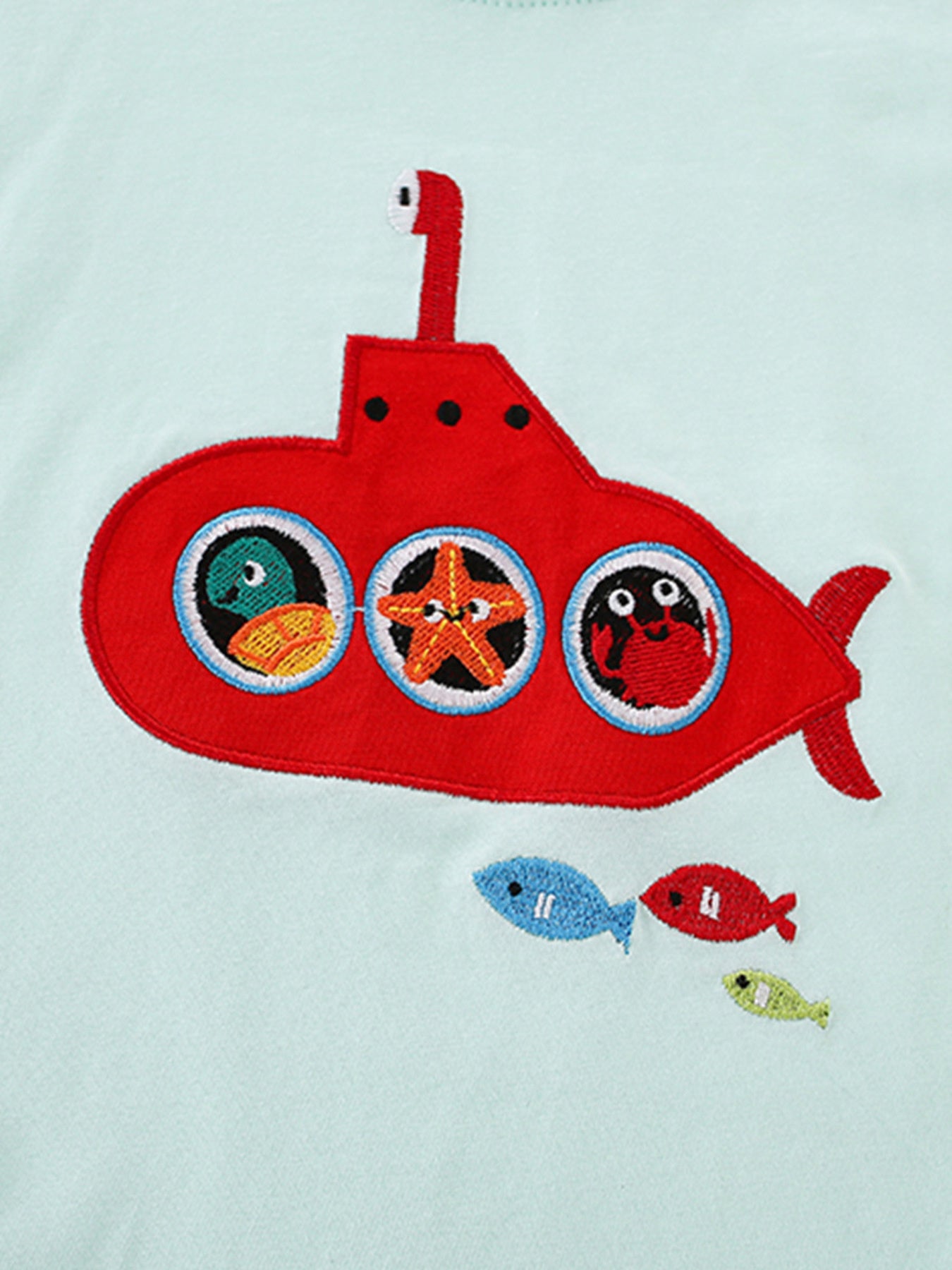 Close detail of the red embroidered submarine with sea creatures in its round porthole windows