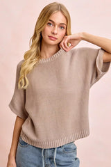 Front view of washed mocha dolman knit top with hand resting near neckline.