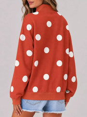 Back view of red mock neck oversized sweatshirt with large white polka dots on model