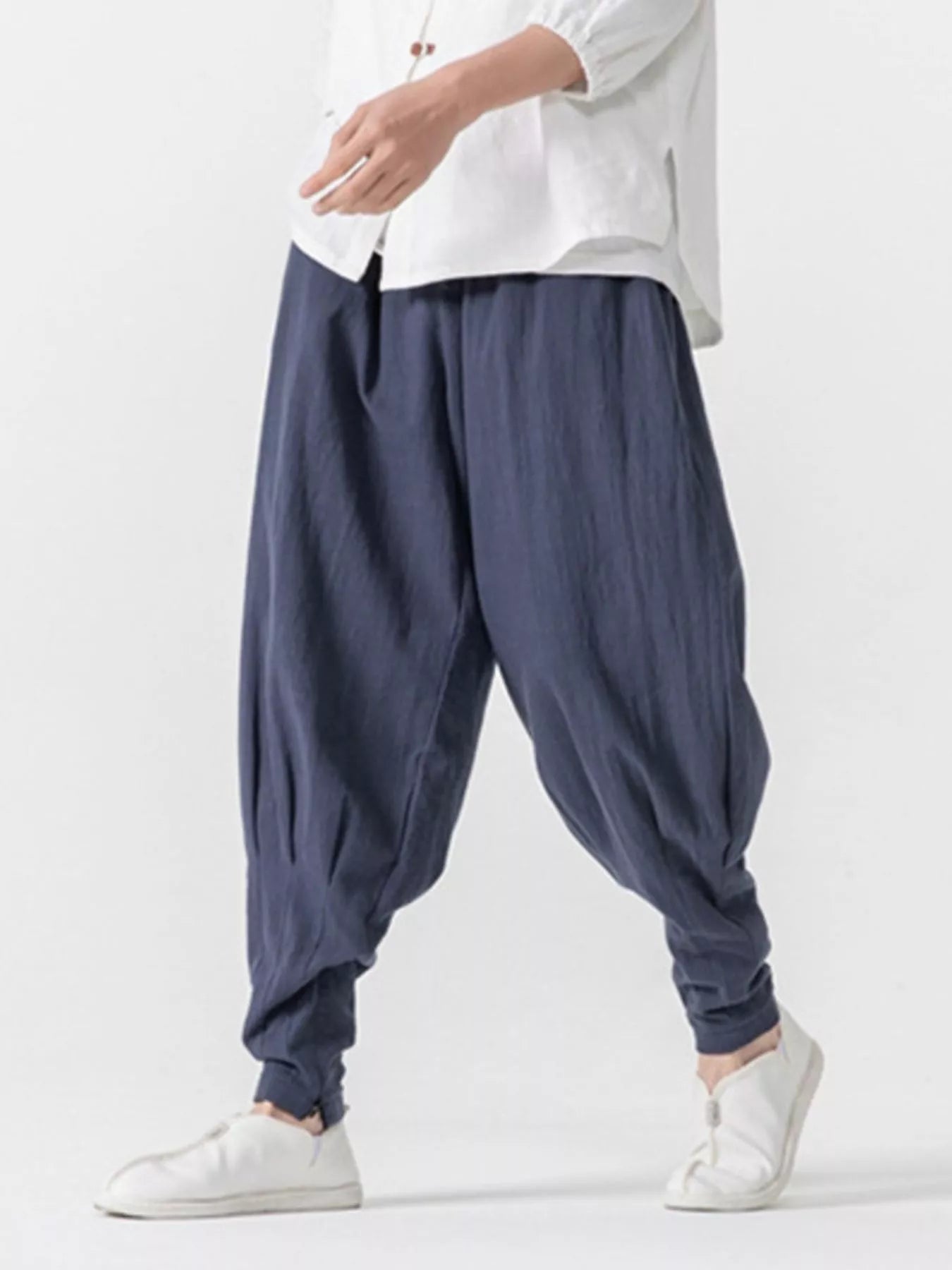 Men's dark navy loose-fit harem pants with pockets and lightweight fabric.