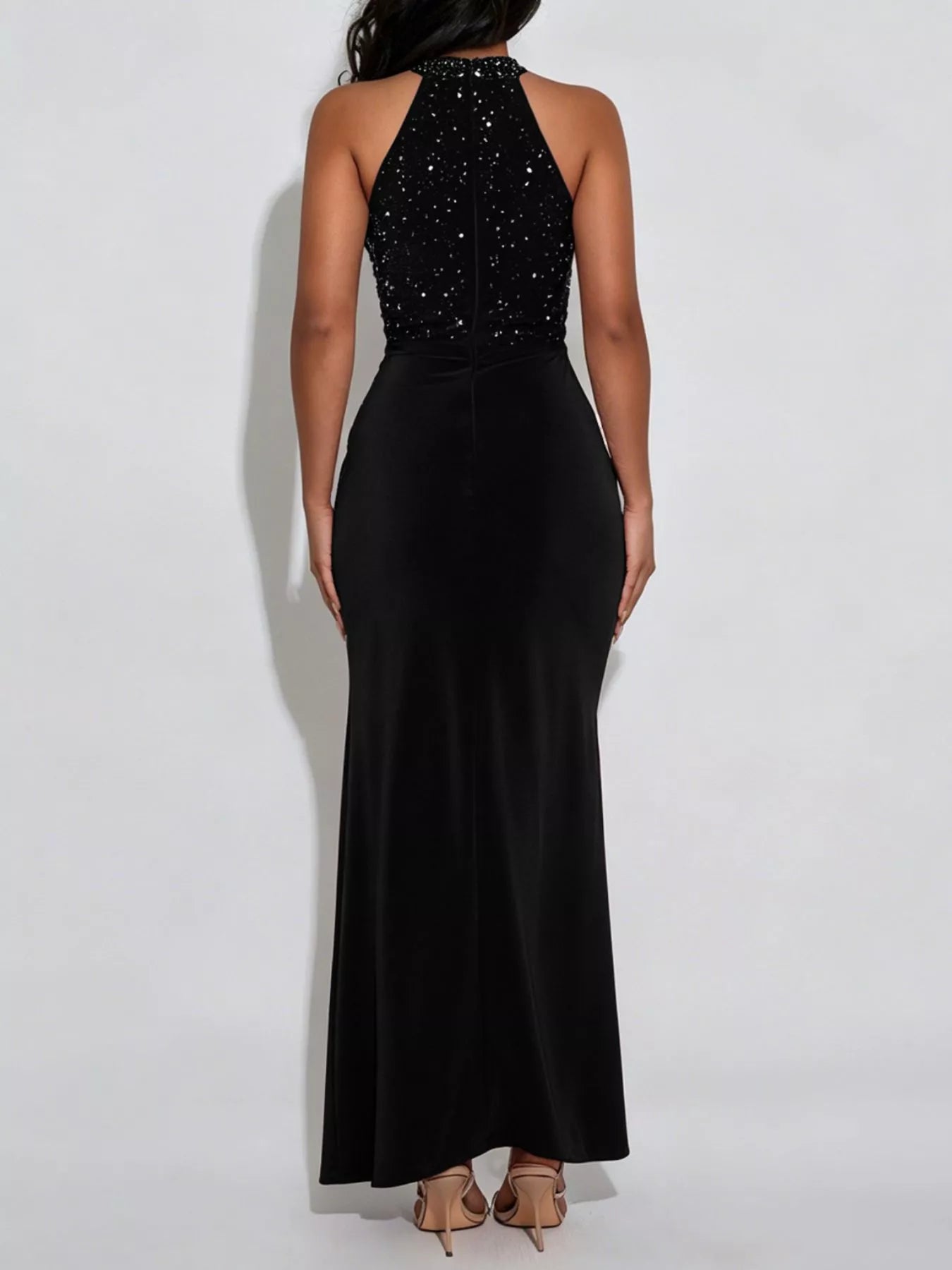 Back view of black sleeveless maxi dress with rhinestone halter bodice on model