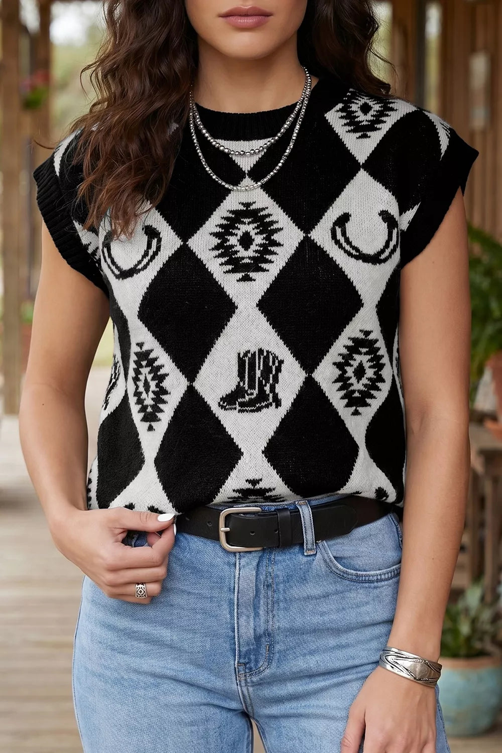 Front view of a black and white diamond knit sweater with western boot and horseshoe motifs