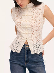 Close front view of white lace sleeveless top showing knot buttons and scalloped hem