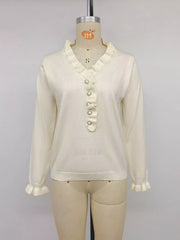 Cream ruffle trim V neck knit top with pearl buttons displayed on mannequin front
