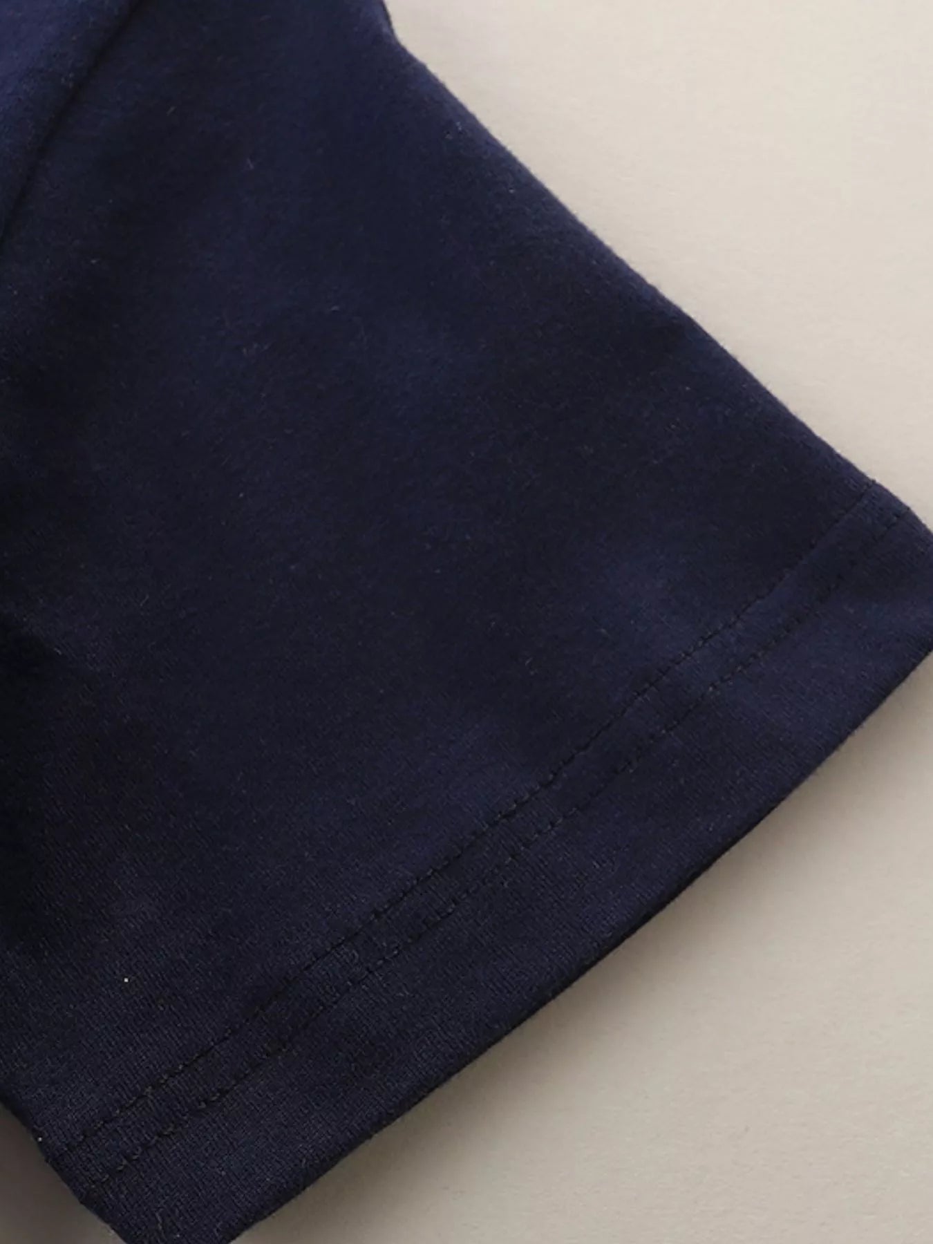 Close-up of the black short sleeve hem with neat double stitching