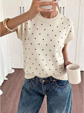 Front view of a cream short sleeve sweater with small black polka dots and round neck