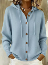 Front view of a light blue hooded knit cardigan with brown buttons and drawstrings