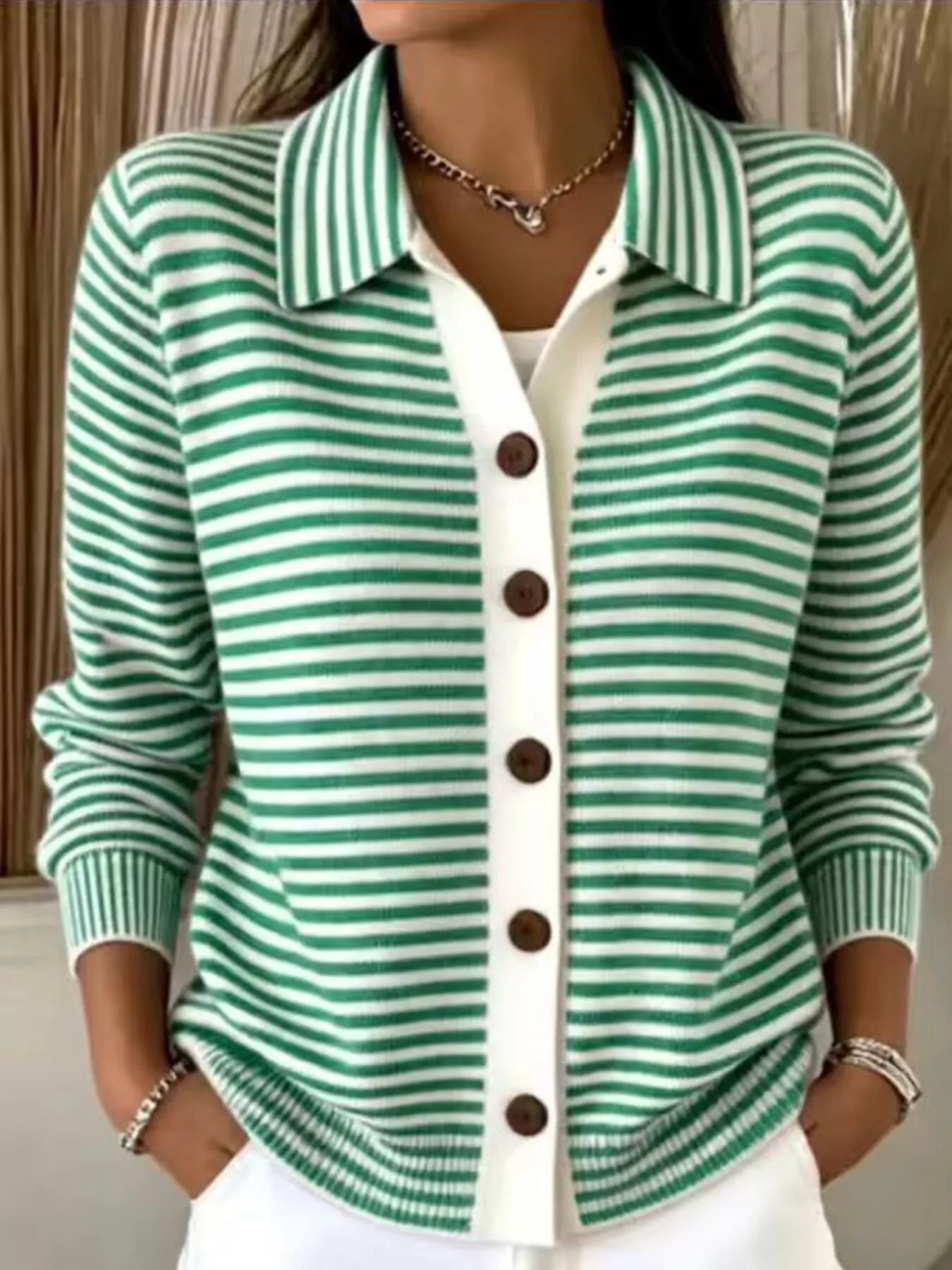 On-model front view of green and white striped collared cardigan with brown buttons