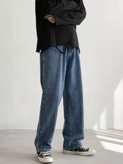 Men's Light Blue loose fit wash jeans on model, front view with arms crossed.