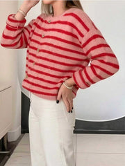 Side front view of pink and red striped button down cardigan with long sleeves and white pants