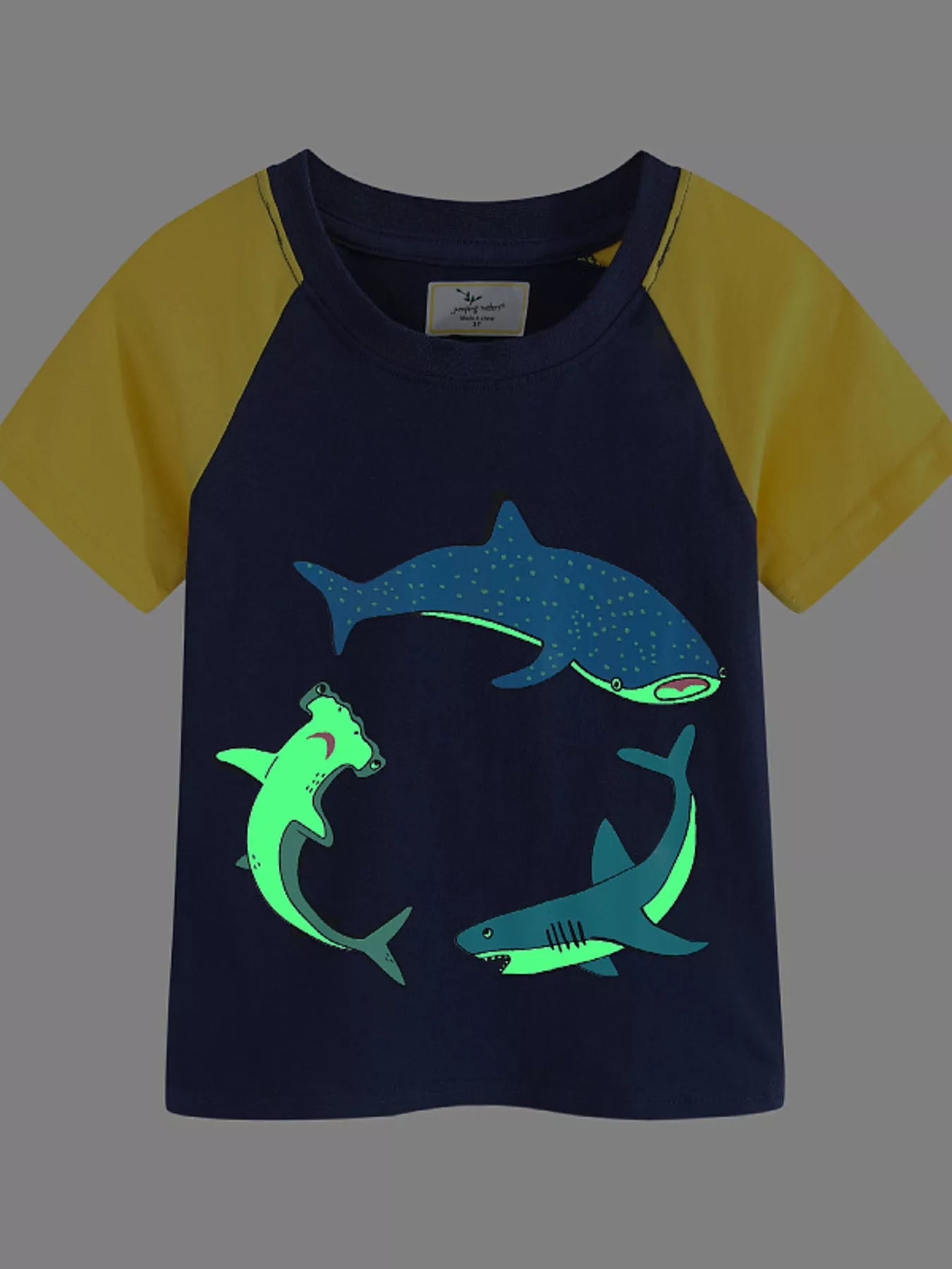 Flat front view of a dark navy children's raglan t-shirt with yellow sleeves and shark prints