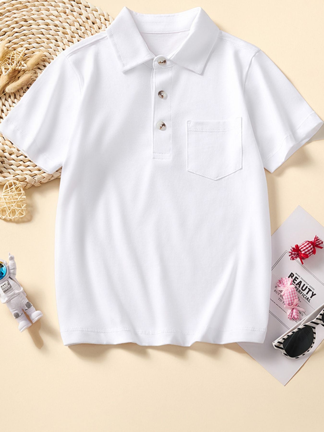 Flat front view of a white children's polo with collar three buttons and chest pocket