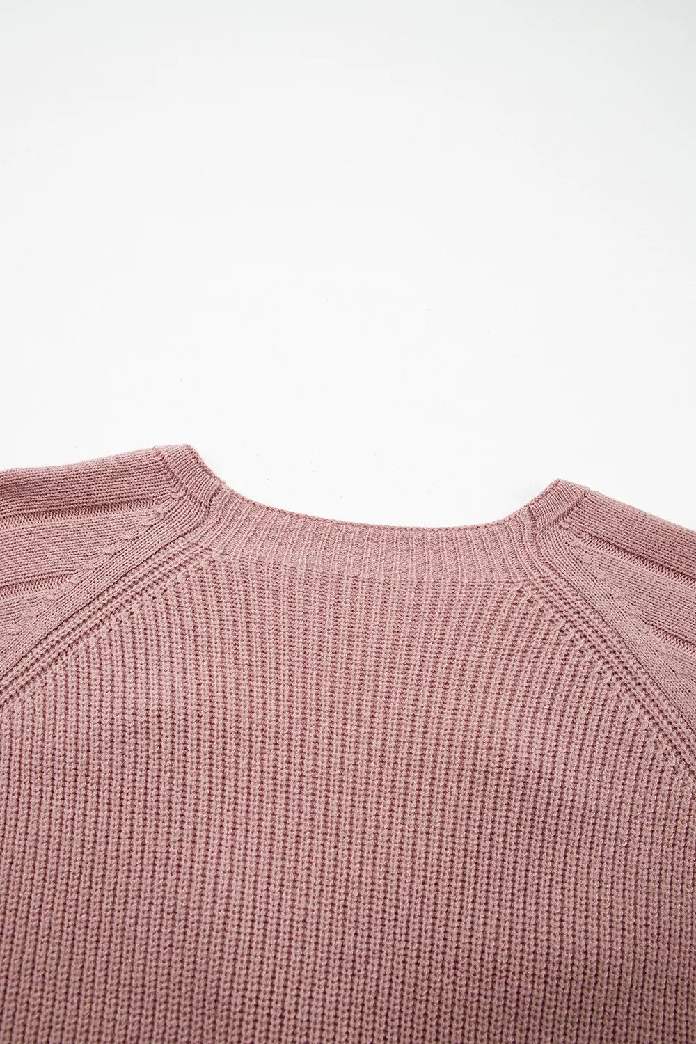 Flat lay close-up of the back neckline and ribbed knit on a dusty pink cardigan
