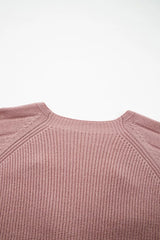 Flat lay close-up of the back neckline and ribbed knit on a dusty pink cardigan