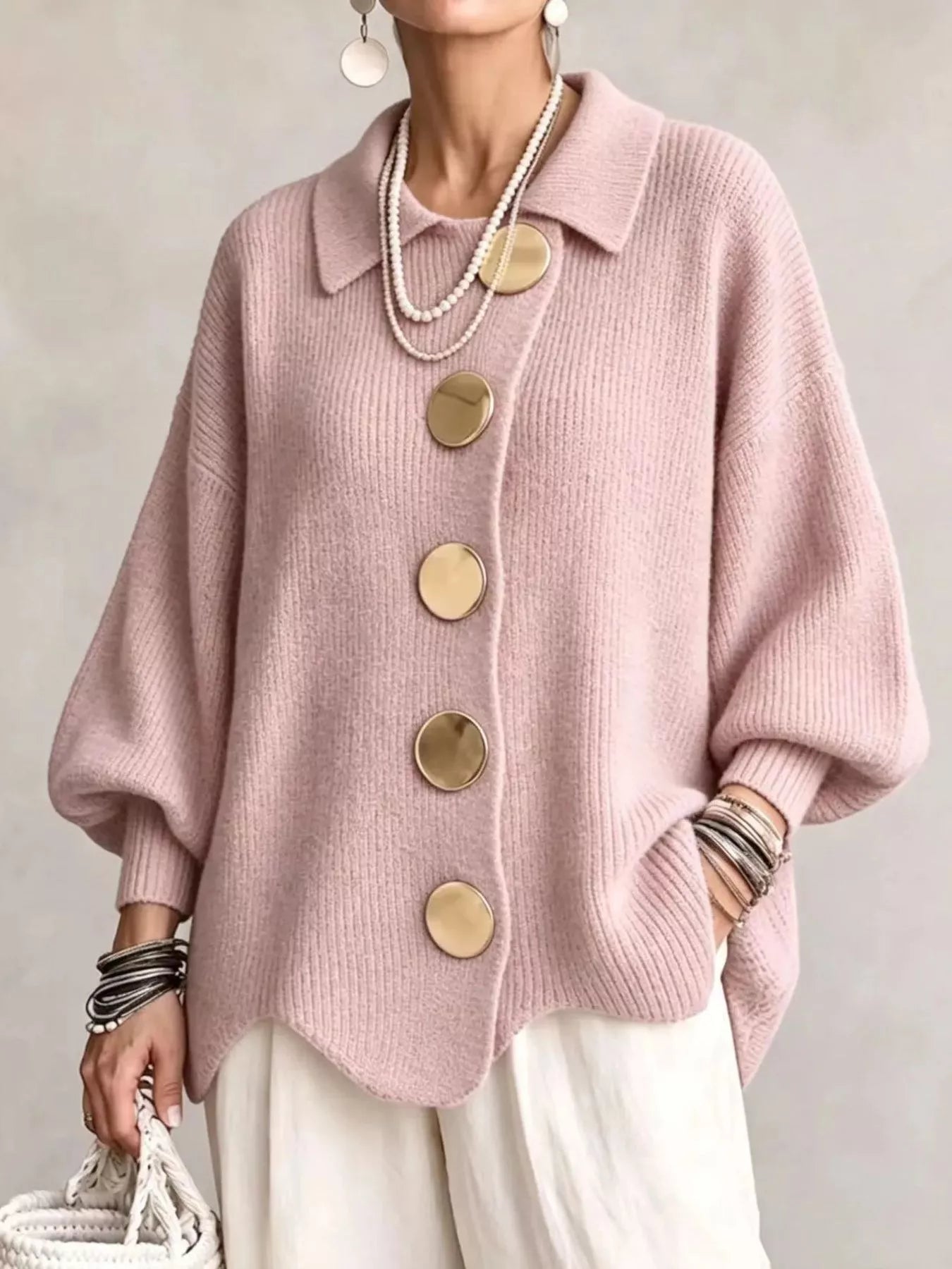 Front view of a pale pink knit cardigan with large gold buttons