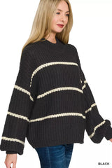 Side view of black oversize striped sweater with cream horizontal stripes and jeans