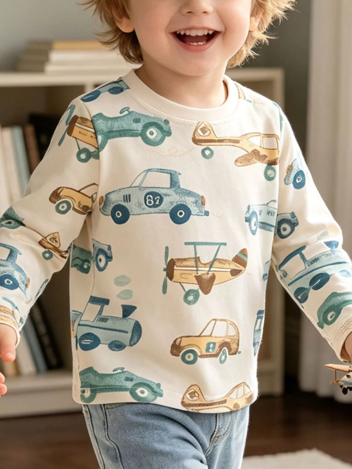 Cream children's long sleeve T-shirt shown worn with a blue and tan cars, planes and trains print