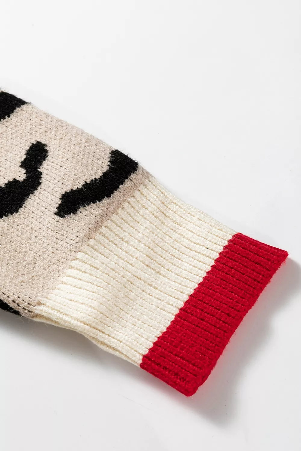 Close view of leopard print sleeve with cream and red ribbed cuff.