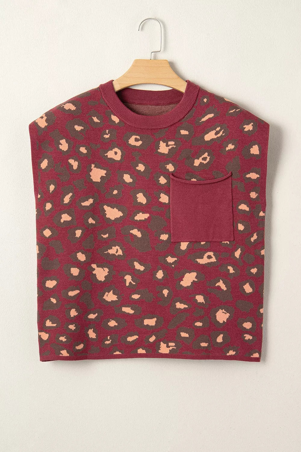 Hanging front view of a deep red leopard print knit top with a chest pocket