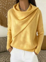 On-model front view of a yellow cowl neck sweater with a draped asymmetric collar and long sleeves