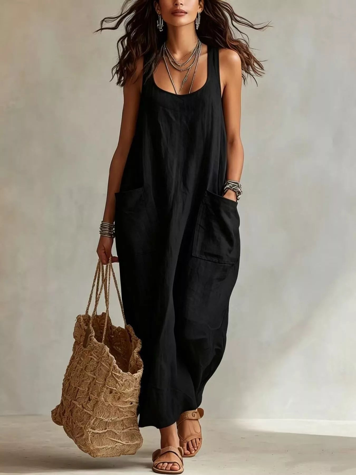 Model wearing black sleeveless scoop neck maxi dress, full view with large front pockets