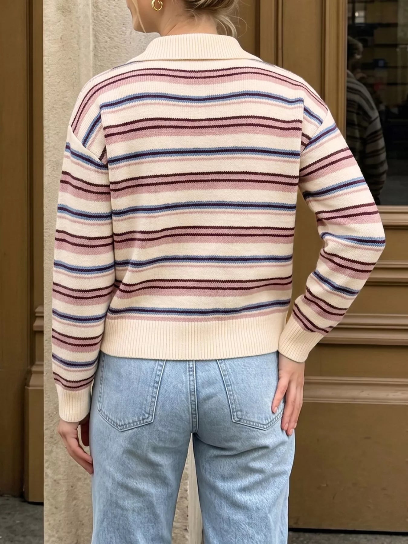 Back view of a cream striped polo sweater with pink, blue, and burgundy stripes