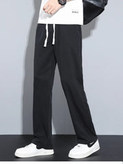 Men's black casual pants with wide legs and a drawstring waist.