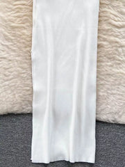 Lower skirt of white ribbed knit midi dress laid flat on soft rug