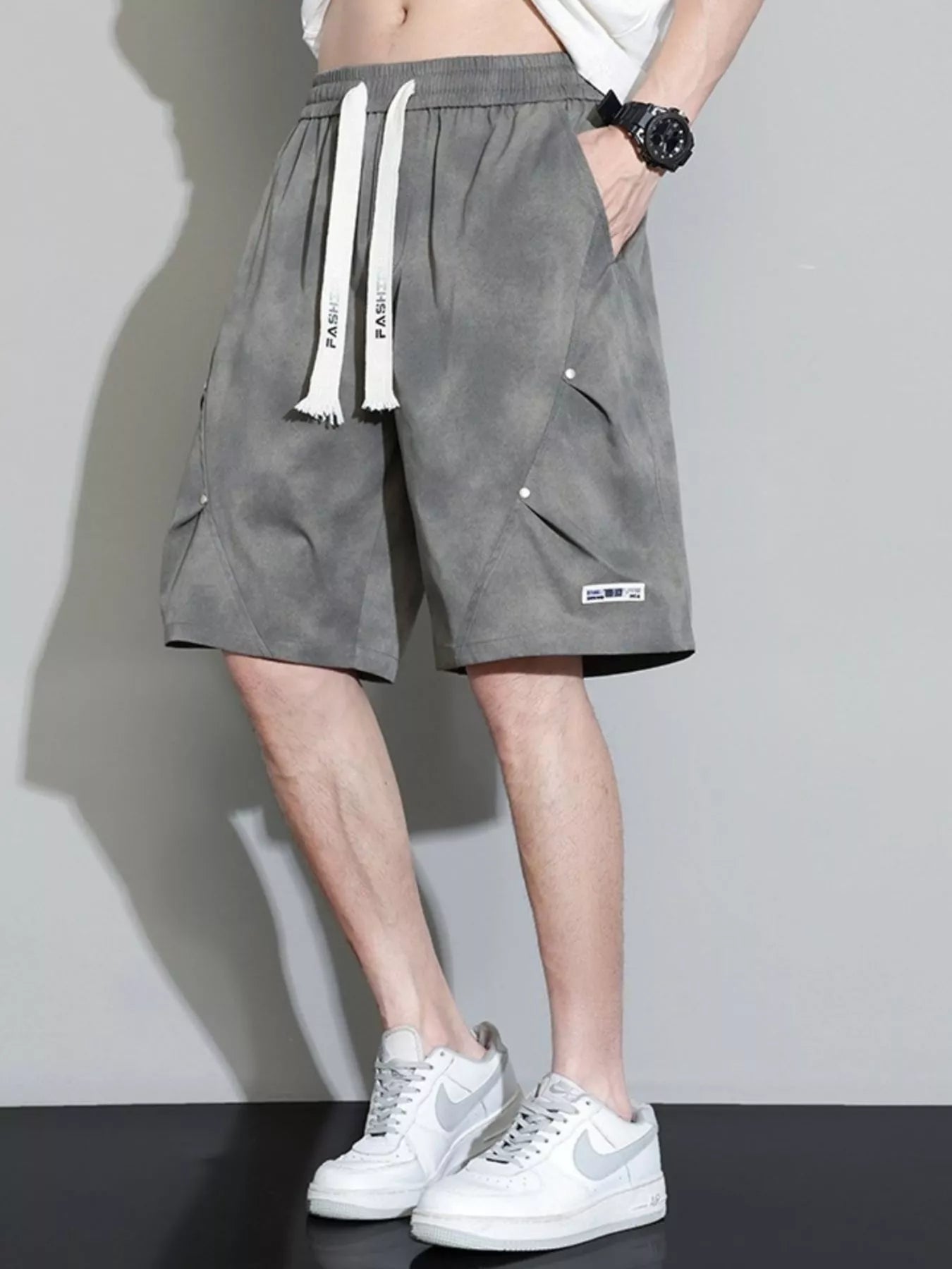 Men's military green cargo shorts with a drawstring waist and pockets.