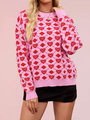 Close front view of a pink knit sweater with red heart argyle pattern and ribbed cuffs