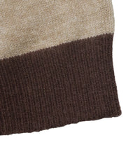 Close up of brown ribbed hem below beige and brown color block knit.