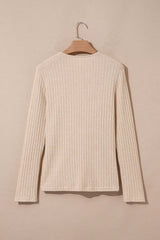 Cream ribbed long-sleeve top with a round neckline hanging on a wooden hanger